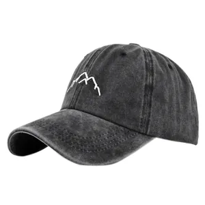 Detail of mountain embroidery on washed dark gray vintage cotton baseball cap