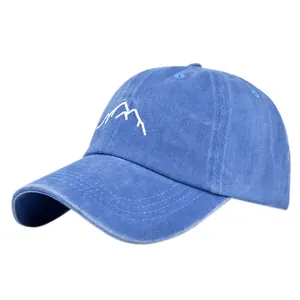 Detailed view of washed navy cotton fabric and white mountain embroidery on baseball cap