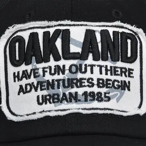 Close-up of Oakland embroidery on a black baseball cap with vintage distressed details