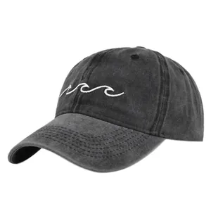 Detailed close-up of wave embroidery and washed cotton texture on a charcoal baseball cap