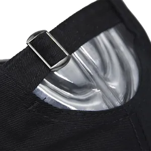 Detail of adjustable metal buckle and cotton fabric texture on black baseball cap