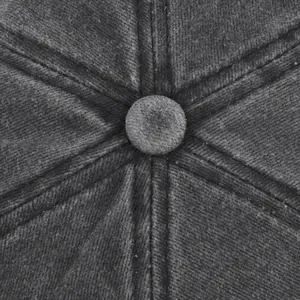 Macro shot of the stitched crown and top button on a washed dark gray cotton baseball cap