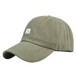 Détail de profil d'une casquette de baseball en coton vert olive avec broderie m blanche