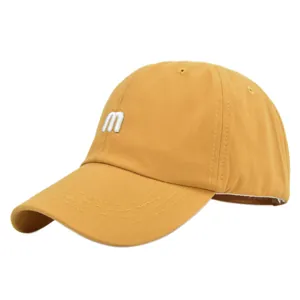 Détail d'une casquette de baseball jaune moutarde avec lettre M brodée et visière courbée
