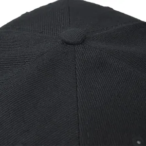 Close-up of durable black twill fabric stitching and top button on the baseball cap