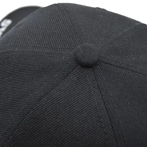 Macro shot of black tactical baseball cap crown with stitch details and fabric texture