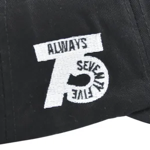 Detail van wit 3D-borduurwerk met ALWAYS 75 op het zwarte baseballpet-materiaal