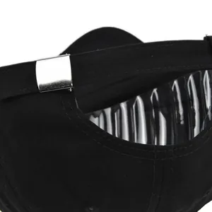 Détail de la boucle métallique argentée réglable à l'arrière d'une casquette noire