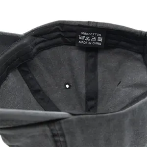 Dettaglio dell'etichetta 100% cotone e cuciture all'interno del cappellino grigio