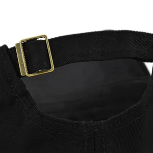 Detail van zwarte katoenen baseballcap met verstelbare bronzen metalen gesp achter