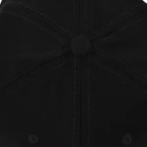 Close-up of the top button and double-stitched seams on a black cotton baseball cap