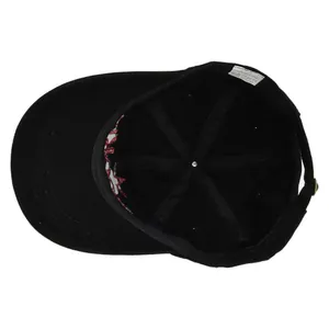 Internal view of black cotton baseball cap showing 6-panel structure and 100% cotton label