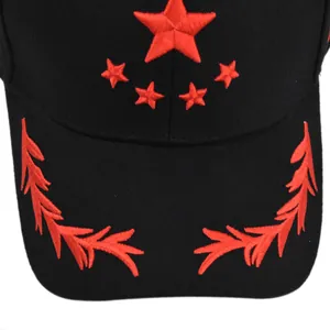 Close-up of high-contrast red star and wheat embroidery on a black cotton baseball cap