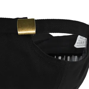 Detail of adjustable brass buckle and cotton strap on the back of a black baseball cap