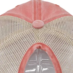 Dettaglio del berretto in tela lavata rosa con foro per coda di cavallo e retro a rete