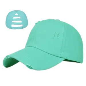 Detail of mint green distressed ponytail baseball cap showing the rear cutout design