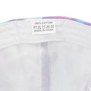 Close-up of the 100% cotton label inside a tie-dye ponytail baseball cap with white lining