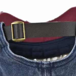 Dettaglio del cinturino in pelle regolabile e fibbia in bronzo su berretto denim vintage
