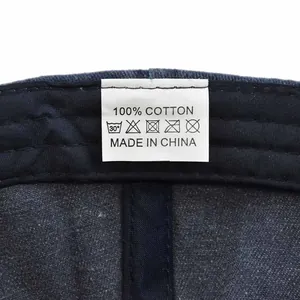 Dettaglio dell'etichetta di lavaggio 100% cotone e istruzioni per la cura sul berretto