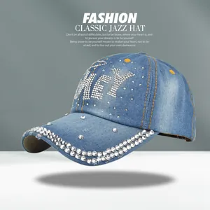 Macro detail of HEY rhinestone letters and denim texture on light blue baseball cap