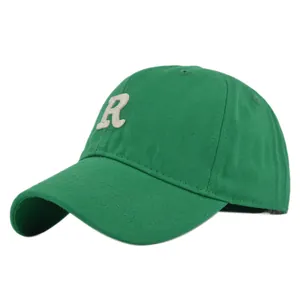 Detail of green cotton baseball cap with white towel-embroidered letter R and stitched eyelets