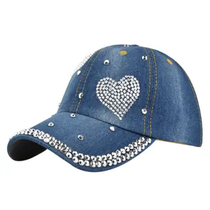 Blue denim baseball cap with rhinestone heart and silver rivet accents on white background
