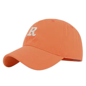 Detailed view of white chenille embroidered letter R on vibrant orange cotton baseball cap
