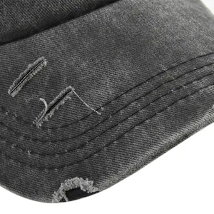 Détail de la visière en coton délavé avec trous usés et surpiqûres de casquette rétro