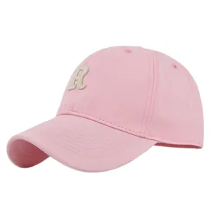 Close-up of pink cotton baseball cap with embroidered letter R patch and curved brim