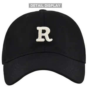 Detailed view of white 3D letter R embroidery on a black cotton baseball cap