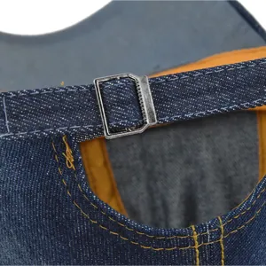 Detail of adjustable metal buckle and yellow stitching on blue denim baseball cap