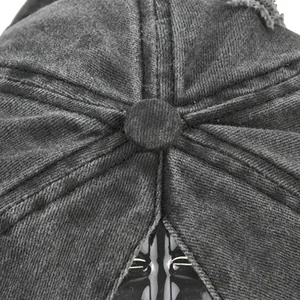 Détail d'une casquette vintage gris délavé montrant le bouton et les coutures usées