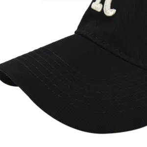 Close-up of white 3D embroidery on a black cotton baseball cap with neat brim stitching