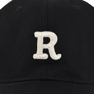 Macro detail of high-quality R letter embroidery on black cotton twill baseball cap