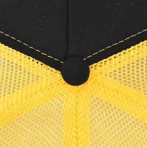 Detailed macro view of black twill cotton and yellow breathable mesh on a baseball cap