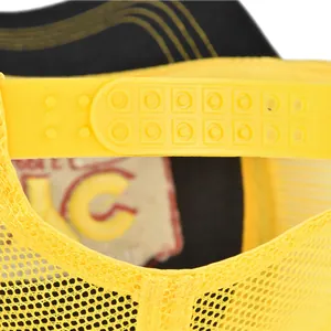Detail of adjustable yellow plastic snapback closure and breathable mesh on trucker hat