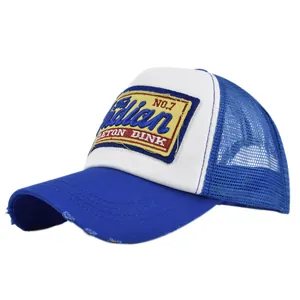 Close-up of distressed brim and embroidered patch on a blue and white mesh trucker hat