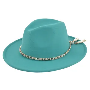 Detail of teal fedora hat featuring gold chain band with white pearls and tassels