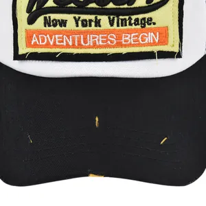 Detail view of vintage New York embroidery patch and distressed brim on the mesh baseball cap