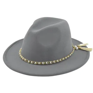 Detail of grey felt fedora featuring gold chain trim, white pearls, and tassel accents