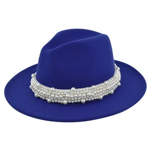 Détail d'un chapeau en feutre bleu roi orné d'un élégant bandeau en perles blanches