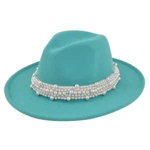 Détail d'un chapeau fedora turquoise élégant avec ruban orné de perles blanches chic