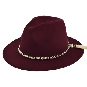 Close-up of wine red wool fedora with gold chain, white pearls and fringe detail