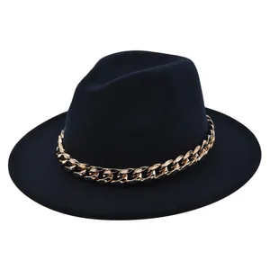 Dettaglio del cappello fedora in feltro nero con una vistosa catena dorata spessa