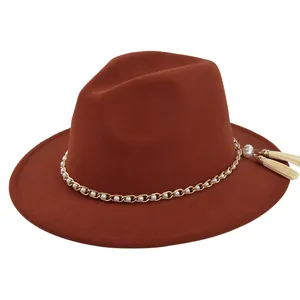Detailed view of brown wool fedora featuring gold chain link and white pearl tassels