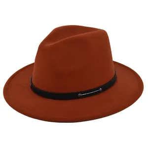 Macro view of dark orange wool felt fedora hat featuring black belt and silver metal studs