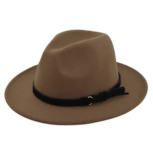 Detail of a brown fedora hat with a black leather band, gold ring and fringe tassel