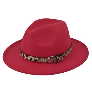 Dettaglio di un cappello fedora rosso in feltro con fascia leopardata e fibbia in metallo
