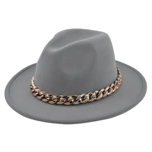 Dettaglio del cappello fedora grigio in feltro con vistosa catena d'oro a tesa larga