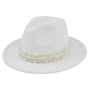 Gros plan sur la bande décorative en perles d'un chapeau fedora blanc en feutre de laine